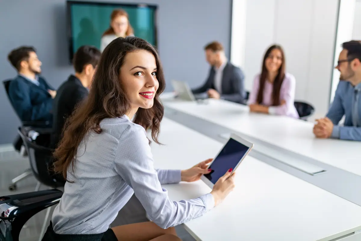 Habilidades do futuro do trabalho - mulher segurando tablet em reunião de trabalho com os colegas